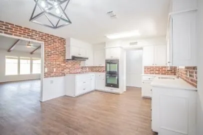 a large white kitchen with a sink a refrigerator and a stove