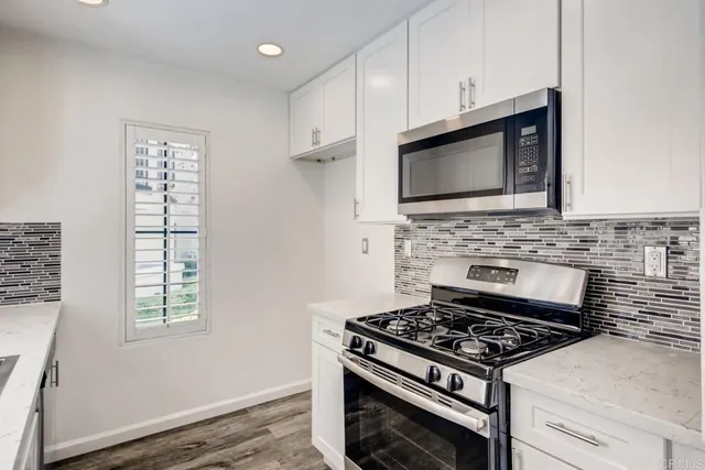 a kitchen with stainless steel appliances a stove a microwave and cabinets