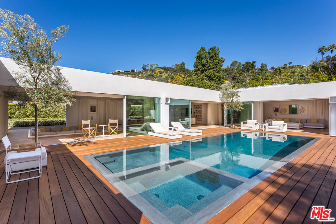 a view of a house with swimming pool and sitting area