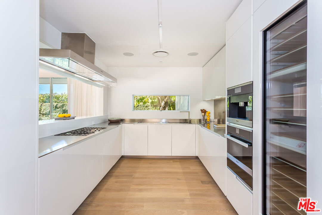 1106 North Hillcrest Road Beverly Hills, CA 90210 - Photo 21 of 54 a kitchen with a refrigerator and a stove