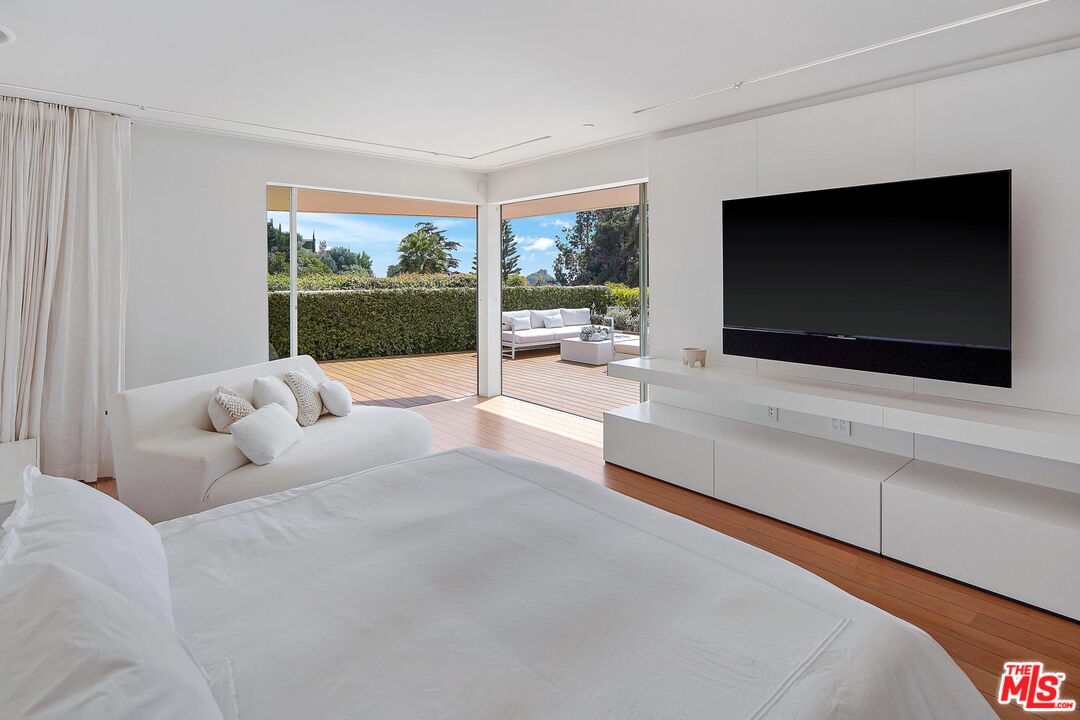 1106 North Hillcrest Road Beverly Hills, CA 90210 - Photo 27 of 54 a living room with furniture tv and a fireplace