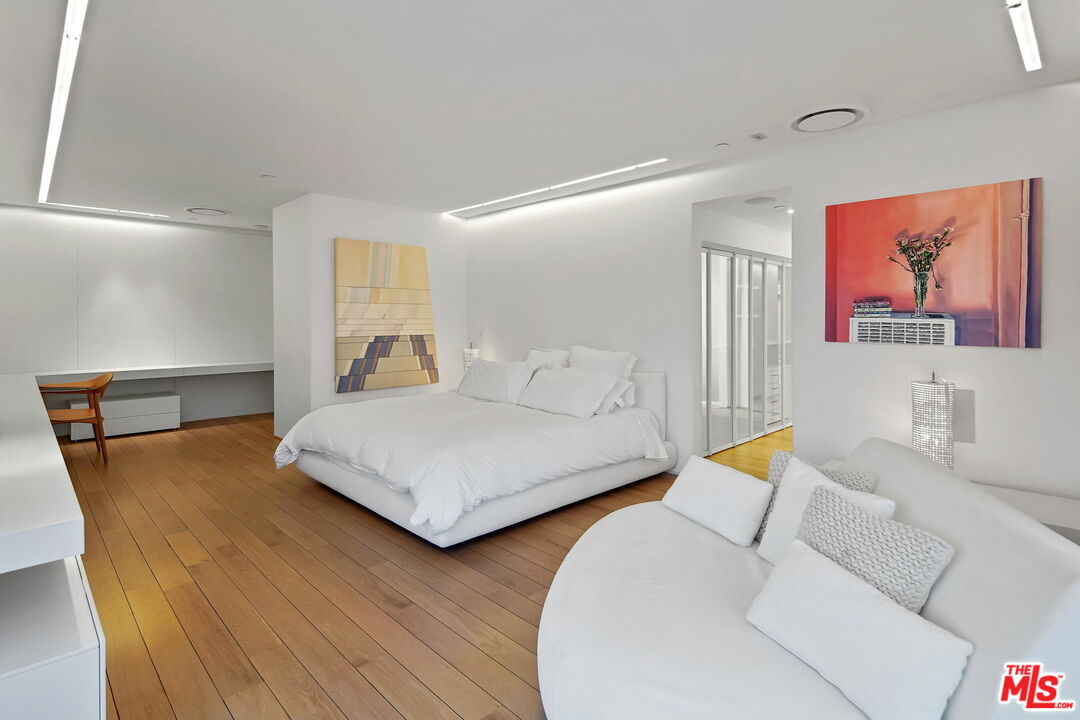 1106 North Hillcrest Road Beverly Hills, CA 90210 - Photo 28 of 54 a bedroom with a bed and wooden floor