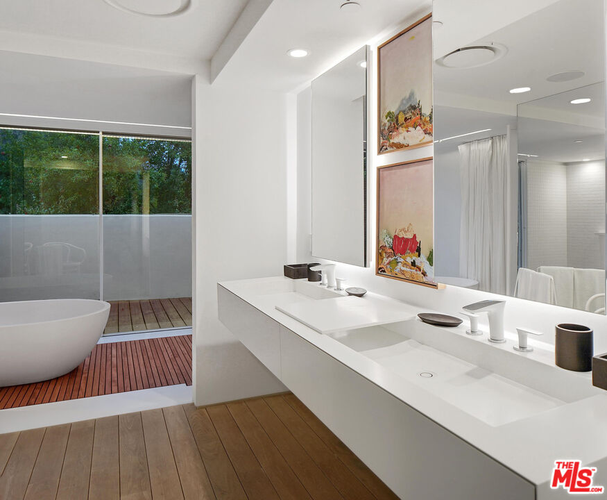 1106 North Hillcrest Road Beverly Hills, CA 90210 - Photo 30 of 54 a bathroom with a sink and a mirror