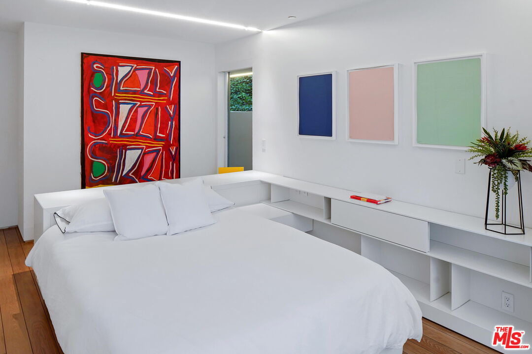 1106 North Hillcrest Road Beverly Hills, CA 90210 - Photo 38 of 54 a bedroom with a large bed and a potted plant