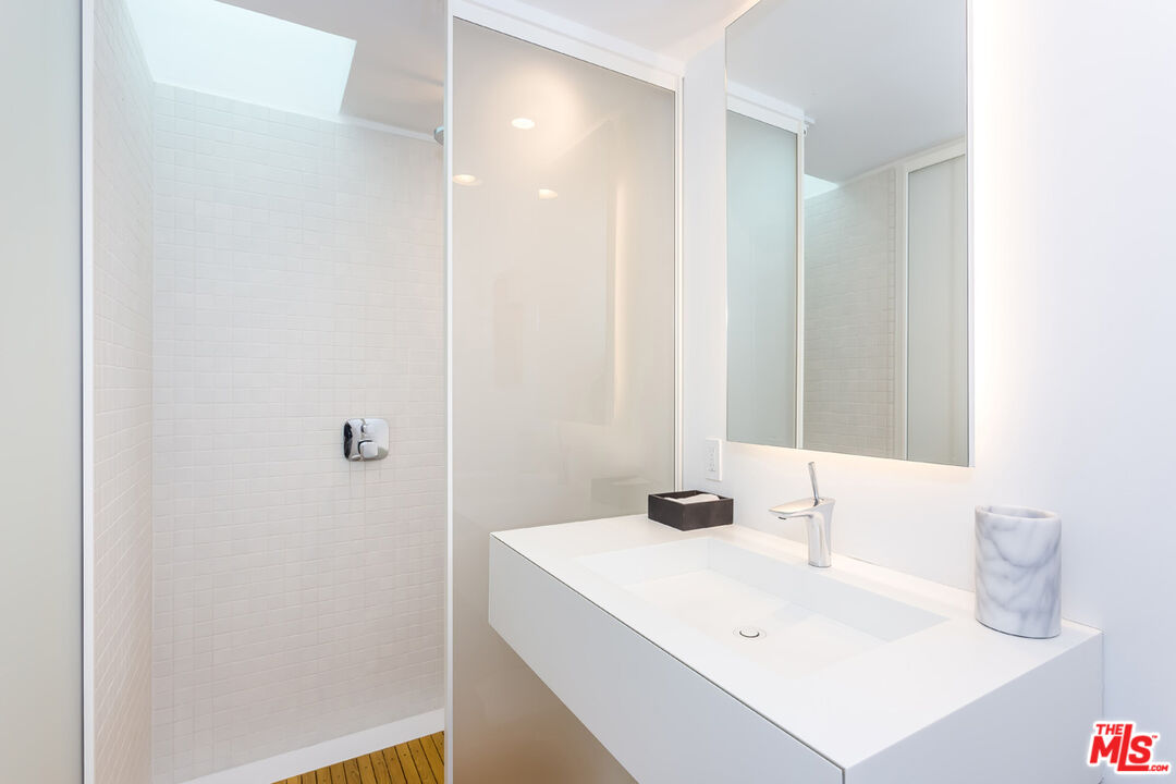 1106 North Hillcrest Road Beverly Hills, CA 90210 - Photo 39 of 54 a bathroom with a sink and a mirror