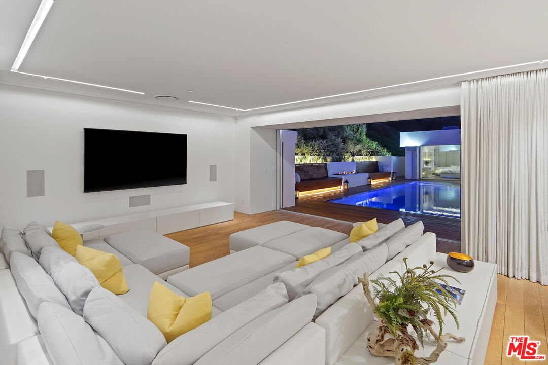 1106 North Hillcrest Road Beverly Hills, CA 90210 - Photo 50 of 54 a living room with furniture and a flat screen tv