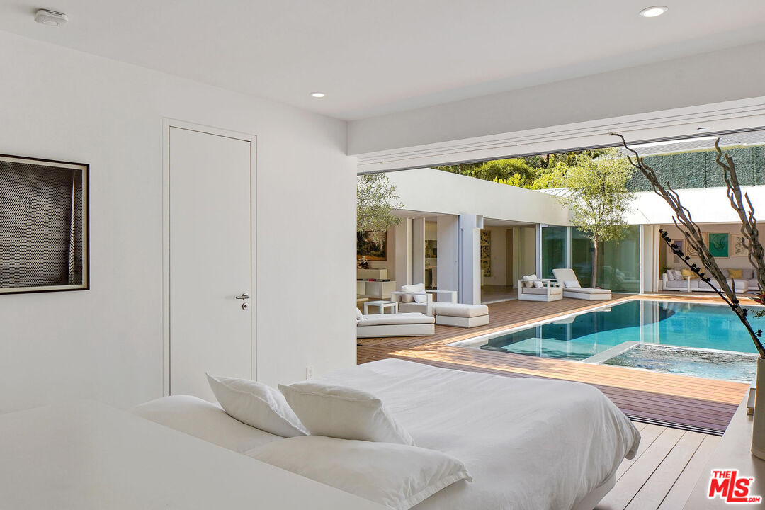 1106 North Hillcrest Road Beverly Hills, CA 90210 - Photo 10 of 54 a living room with a large window and a table