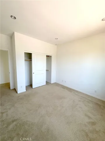 an empty room with windows and closet