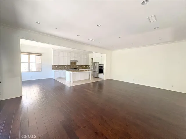 a view of a kitchen with wooden floor and a window