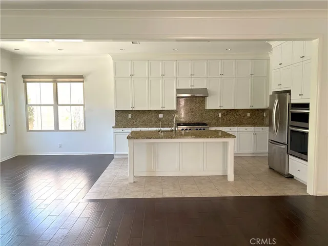 a kitchen with granite countertop white cabinets and stainless steel appliances