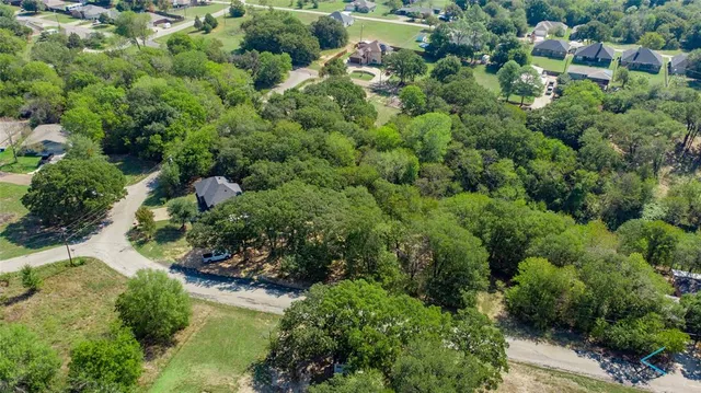 an aerial view of residential house with outdoor space and trees all around