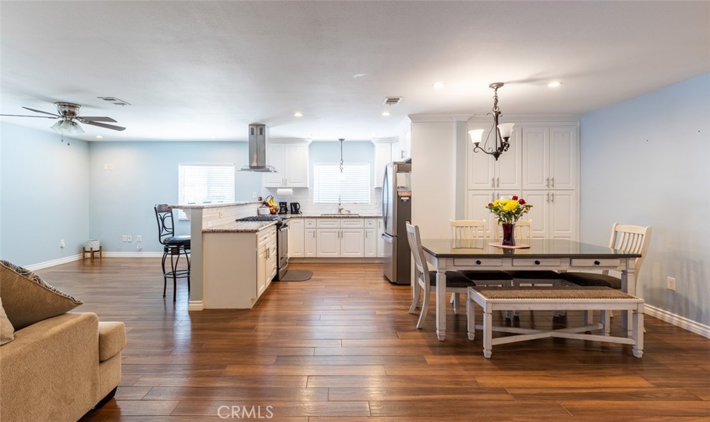 5512 Marcella Avenue Cypress, CA 90630 - Photo 14 of 39 a kitchen with stainless steel appliances a stove a sink cabinets and living room view