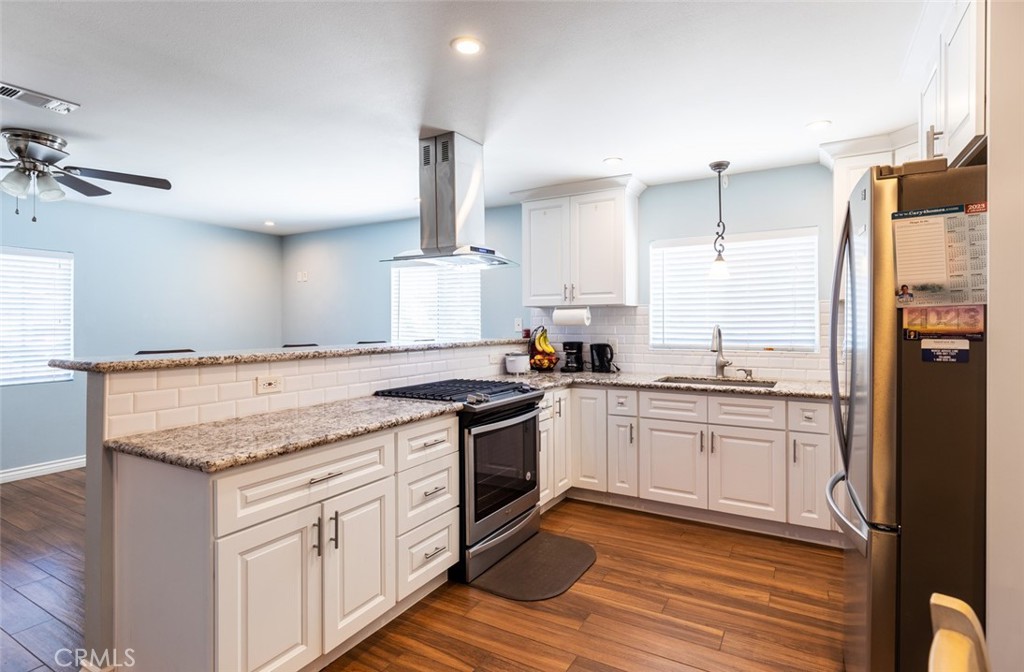 5512 Marcella Avenue Cypress, CA 90630 - Photo 17 of 39 a kitchen with stainless steel appliances granite countertop a stove a sink and a refrigerator