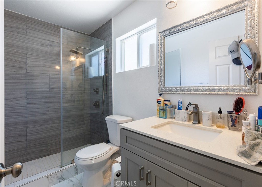 5512 Marcella Avenue Cypress, CA 90630 - Photo 30 of 39 a bathroom with a sink a toilet and shower