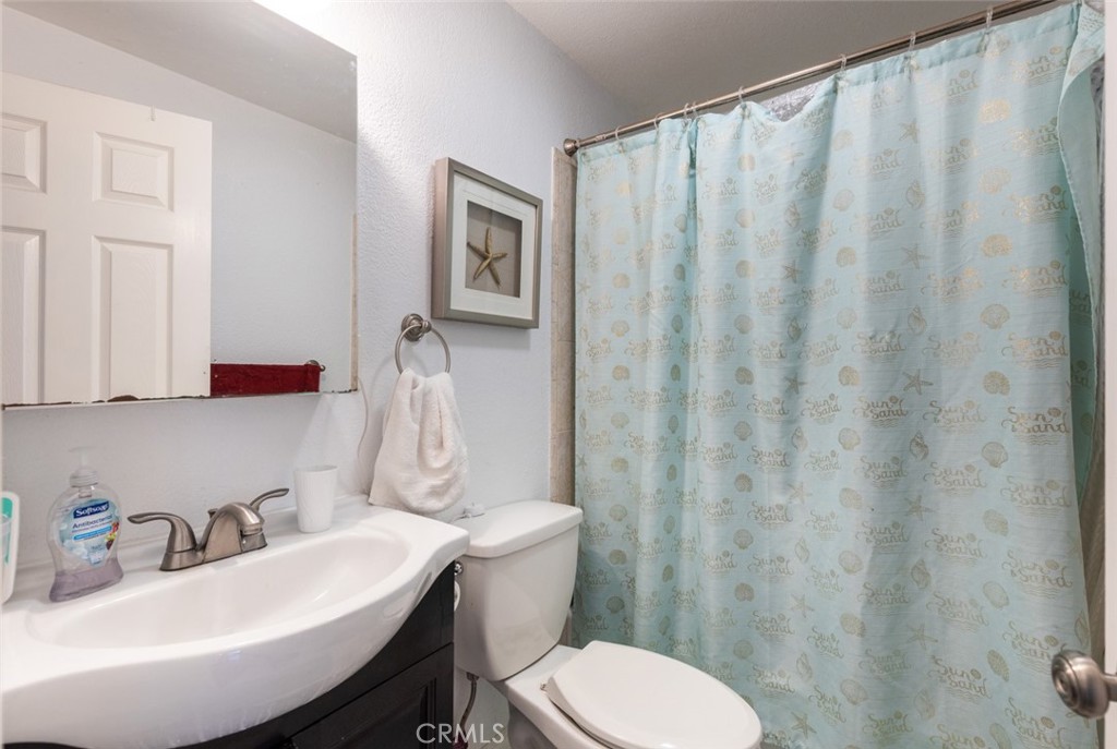 5512 Marcella Avenue Cypress, CA 90630 - Photo 31 of 39 a bathroom with a sink a toilet and a mirror
