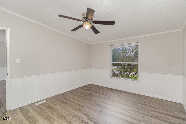437 West Northpoint Road Spring Lake, NC 28390 - Photo 17 of 27 an empty room with wooden floor fan and windows