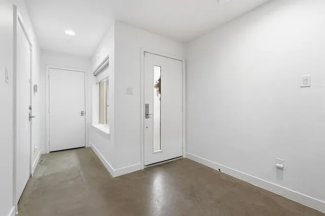 a view of an empty room with kitchen and kitchen view