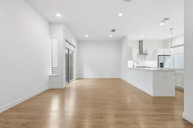 a kitchen with stainless steel appliances granite countertop a sink a stove and a wooden floors