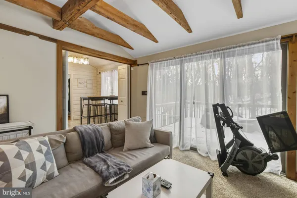 a living room with furniture a large window and a chandelier