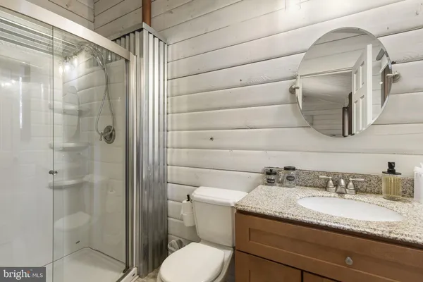 a bathroom with a granite countertop sink toilet and shower
