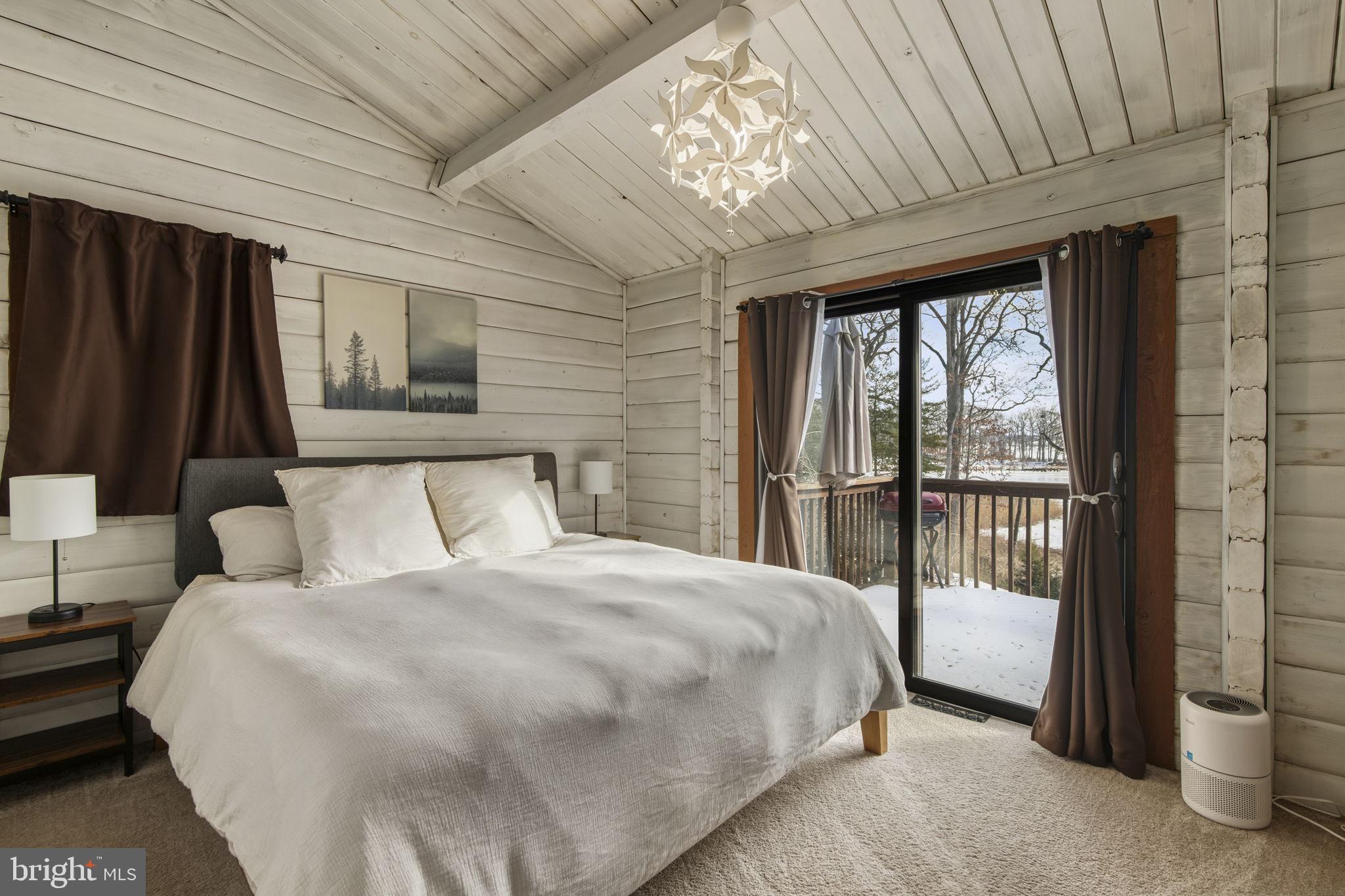 137 Plum Point Road Elkton, MD 21921 - Photo 20 of 54 a bedroom with a large bed and a chandelier