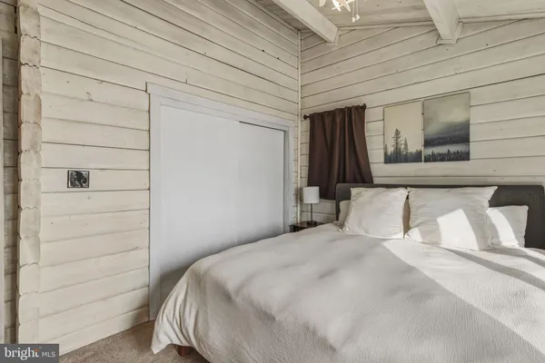 a bedroom with a bed and a painting on the wall