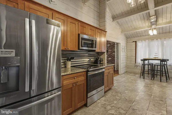 a kitchen with granite countertop a refrigerator and a stove top oven