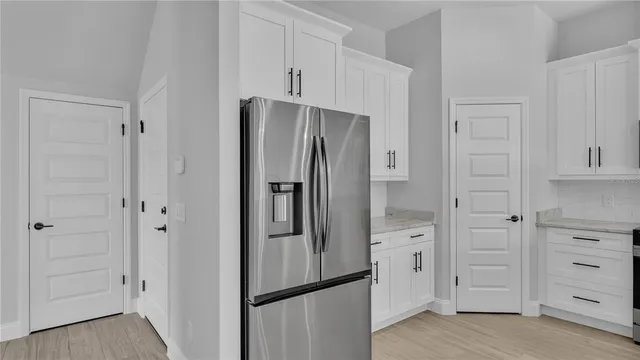 an empty room with wooden floor and a ceiling fan