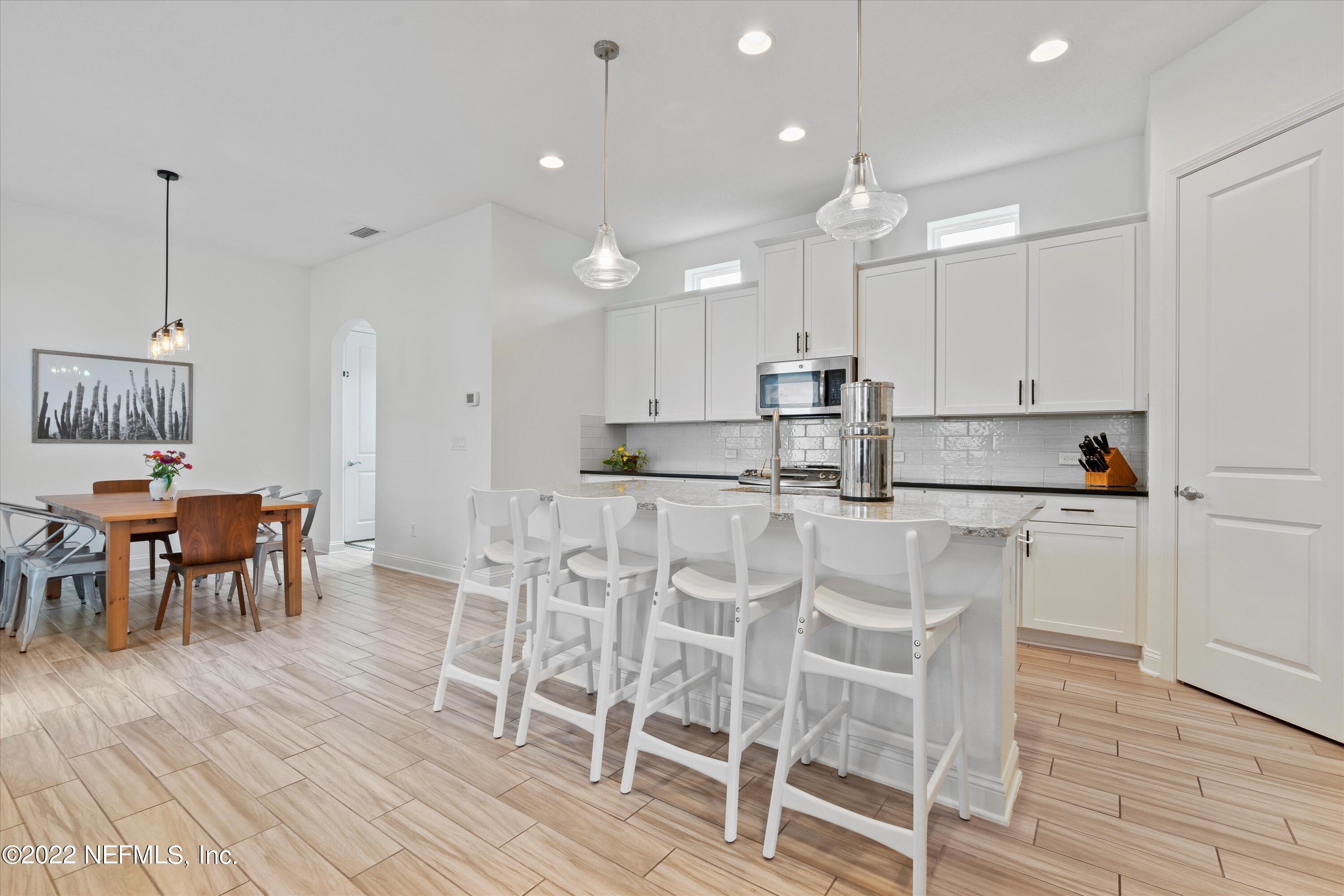 245 Rialto Drive Ponte Vedra, FL 32081 - Photo 8 of 29 a kitchen with kitchen island granite countertop a table and chairs in it