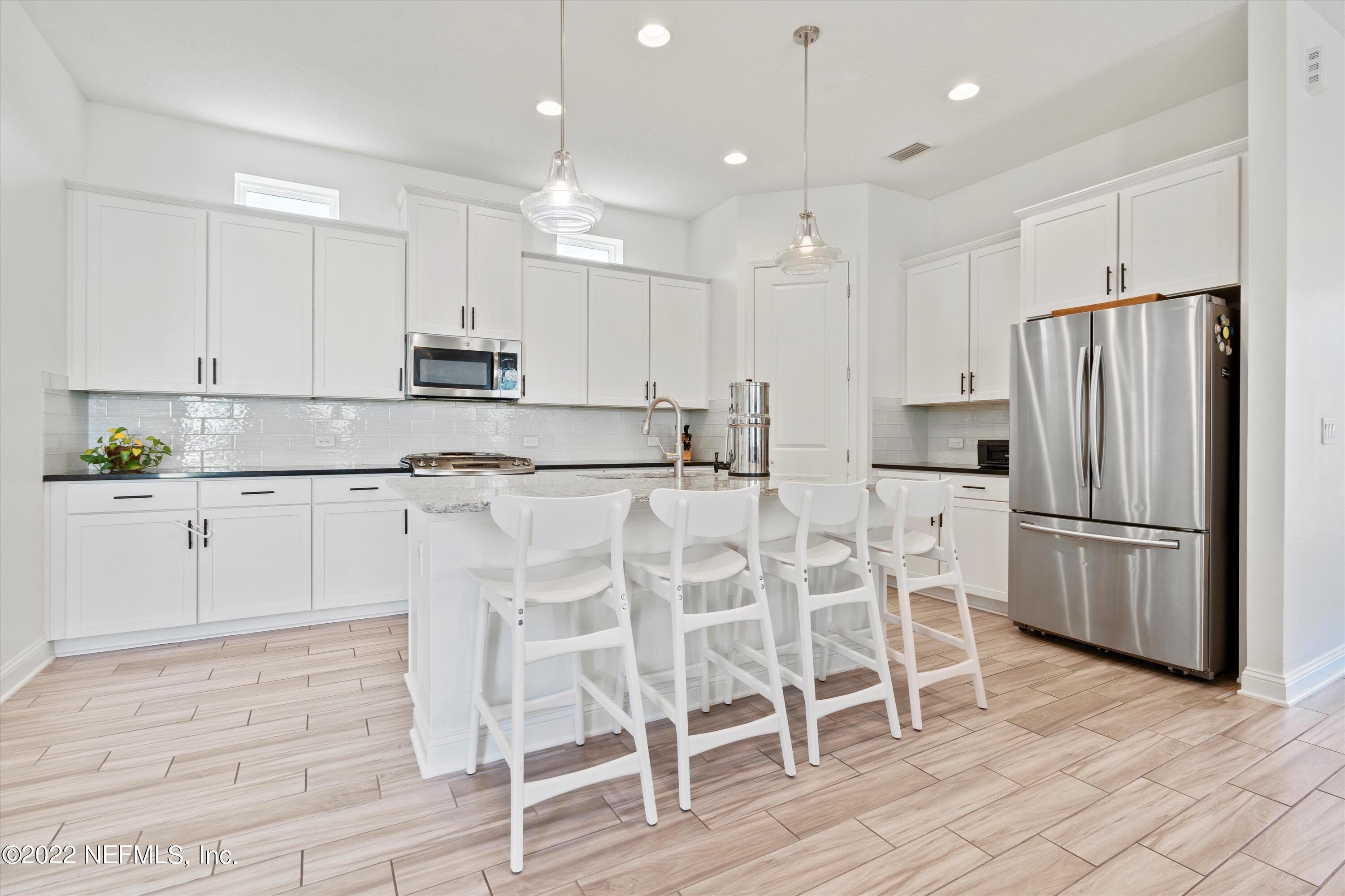 245 Rialto Drive Ponte Vedra, FL 32081 - Photo 9 of 29 a kitchen with white cabinets and stainless steel appliances