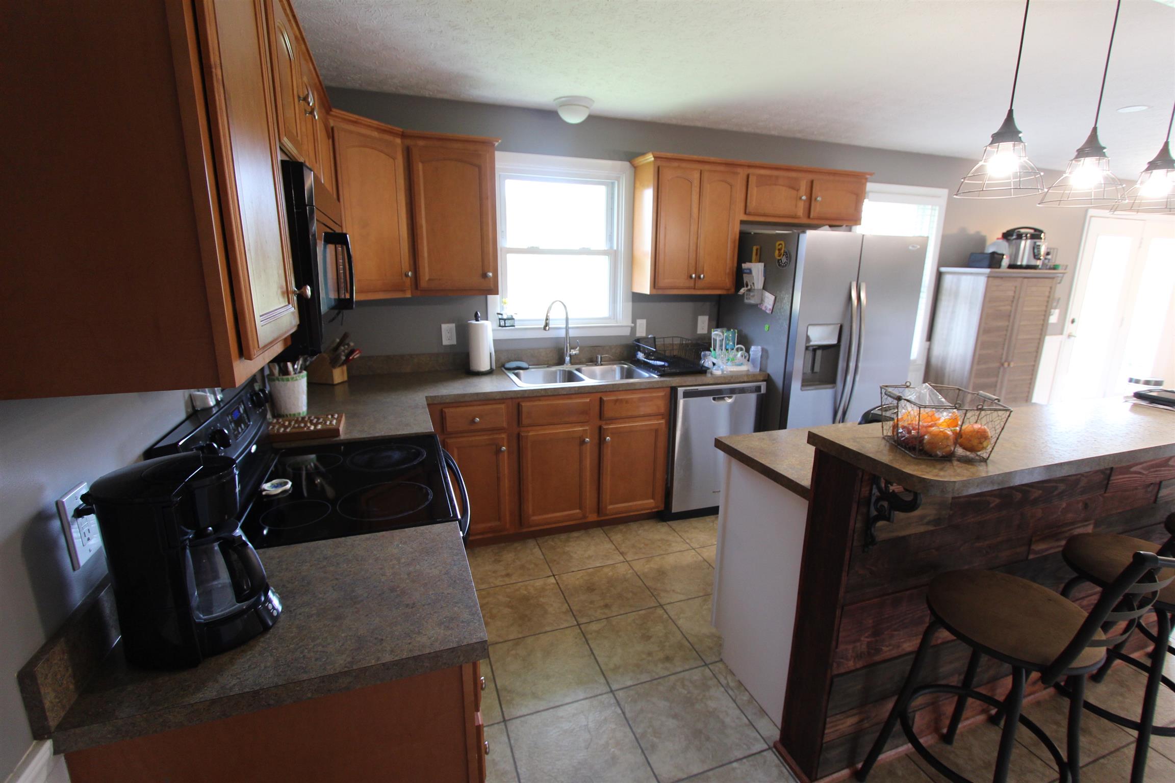 4240 Simmons Bluff Road Lebanon, TN 37090 - Photo 9 of 30 a kitchen with a table chairs refrigerator and window