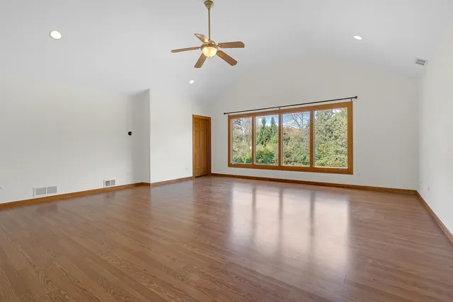 an empty room with a window and a ceiling fan