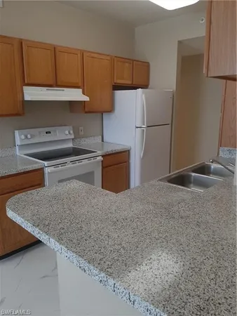 a kitchen with stainless steel appliances granite countertop a sink refrigerator and stove