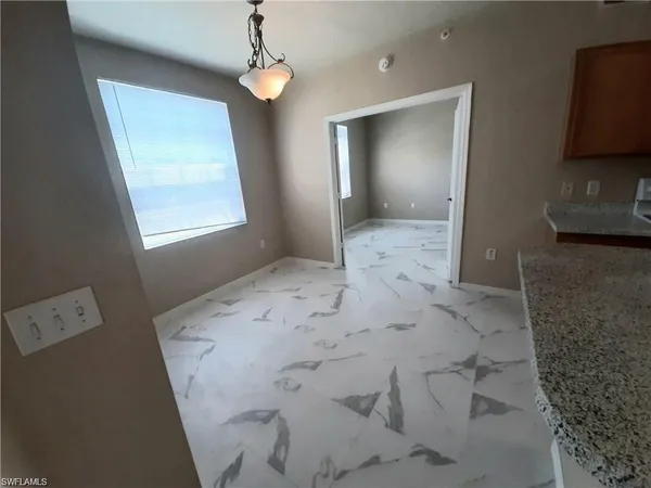 a view of a livingroom with a chandelier fan and a window