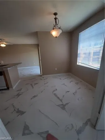 a view of a livingroom with a chandelier fan and windows