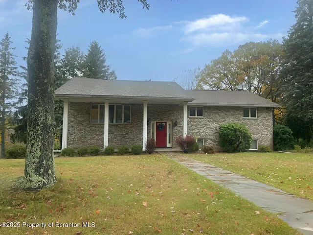 a view of a house with yard and tree