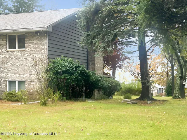 front view of a brick house with a yard