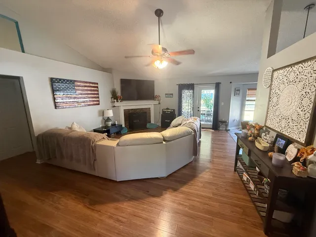 a living room with furniture a fireplace and a flat screen tv