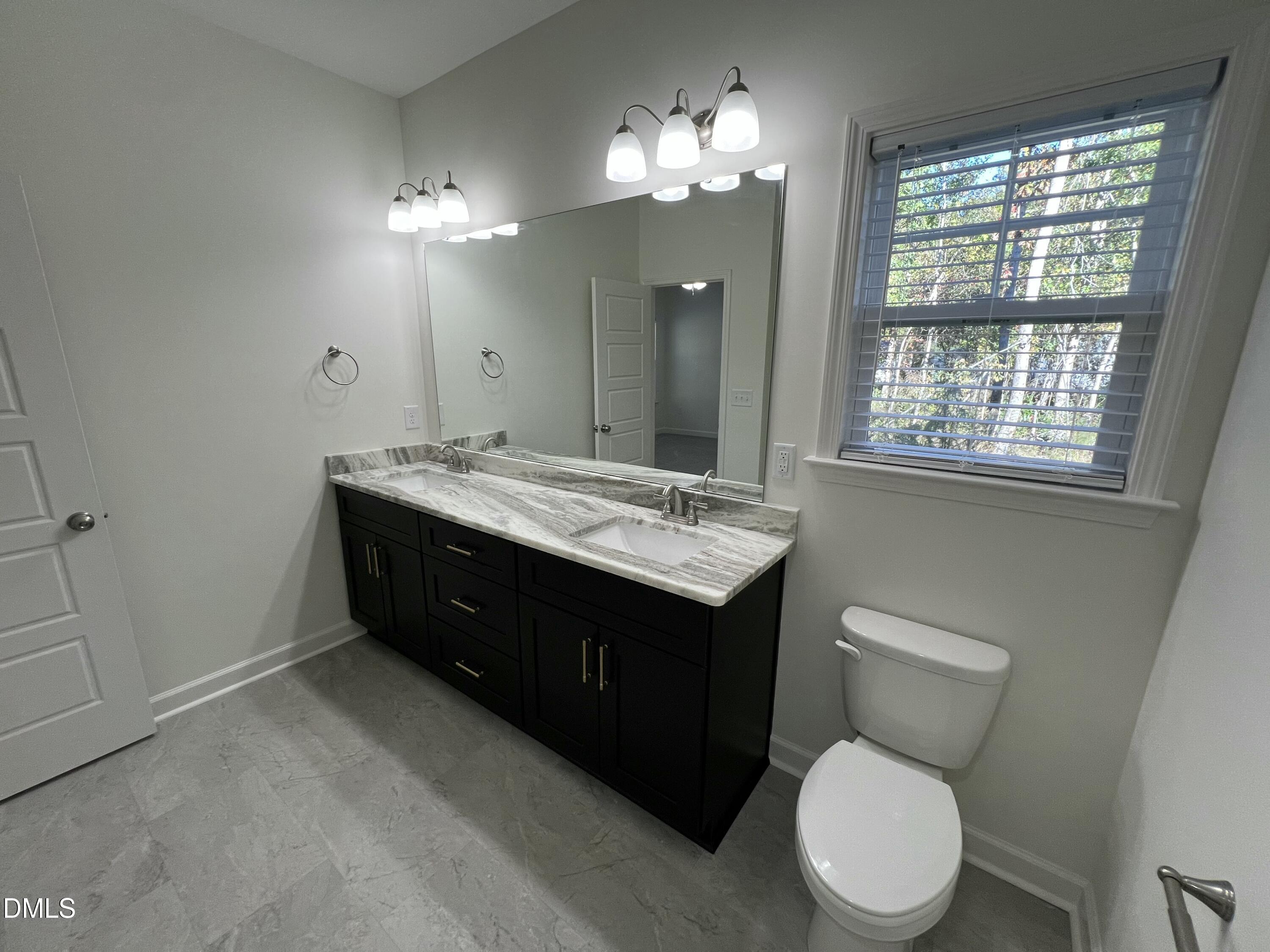 1552 Patterson Road Kinston, NC 28504 - Photo 12 of 23 a spacious bathroom with a granite countertop toilet sink and mirror