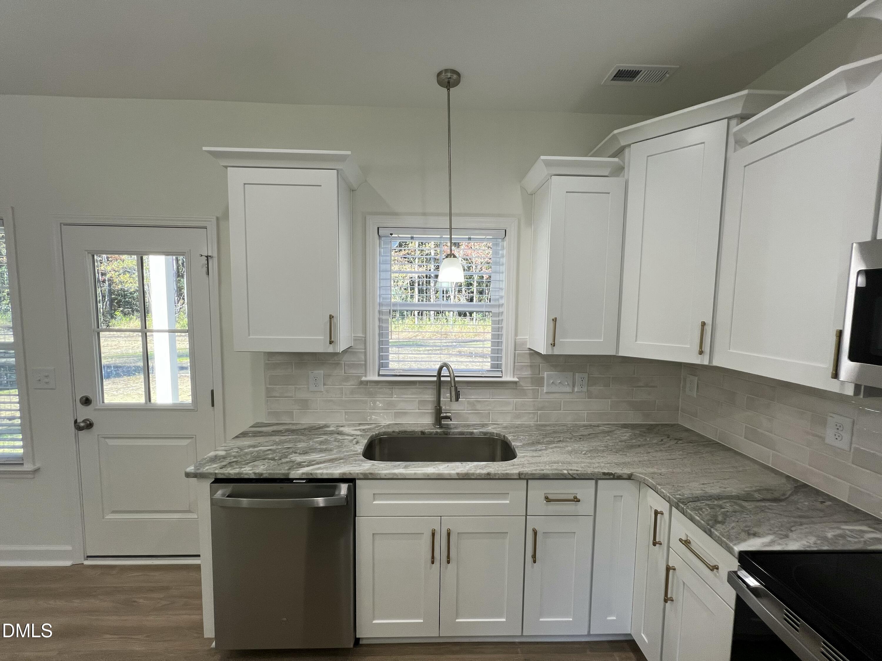 1552 Patterson Road Kinston, NC 28504 - Photo 7 of 23 a kitchen with stainless steel appliances granite countertop white cabinets sink and window