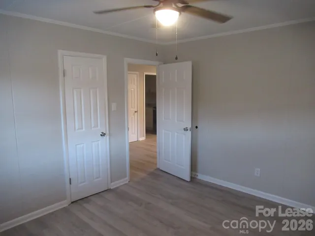 an empty room with wooden floor and closet area