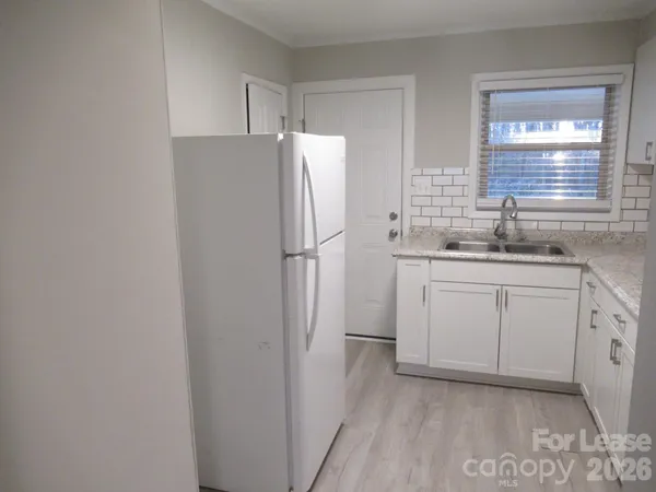 a kitchen with a sink a refrigerator and cabinets