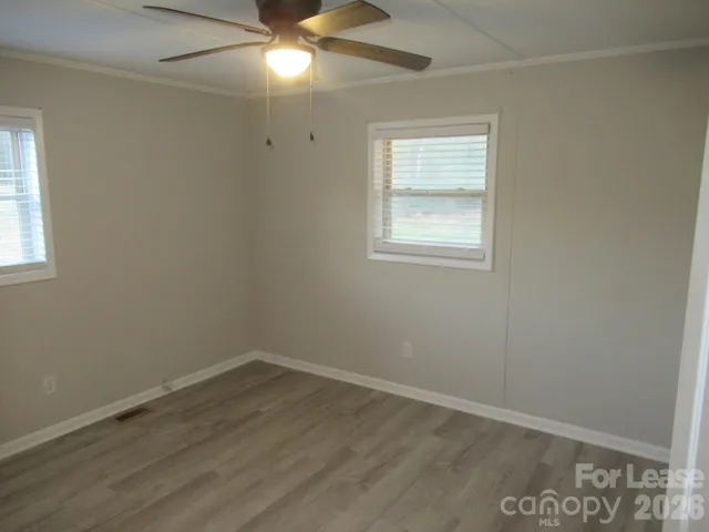 an empty room with a window and wooden floor