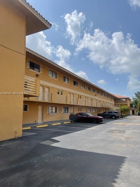 180 Royal Palm Road, Unit 109 Hialeah Gardens, FL 33016 - Photo 3 of 11 a view of a building with car parked