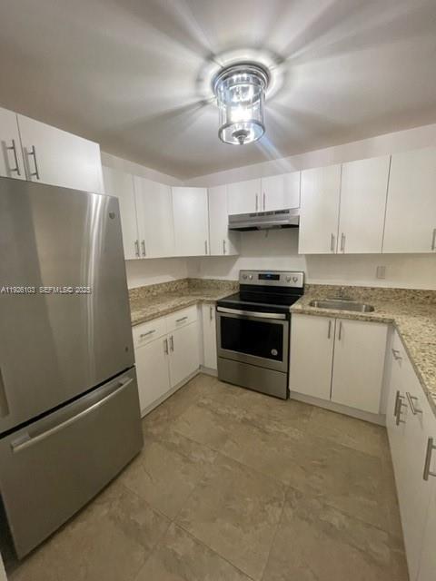 180 Royal Palm Road, Unit 109 Hialeah Gardens, FL 33016 - Photo 6 of 11 a kitchen with granite countertop stainless steel appliances and white cabinets