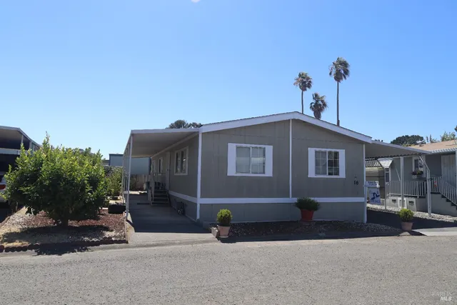 a backyard of a house with barbeque oven and table