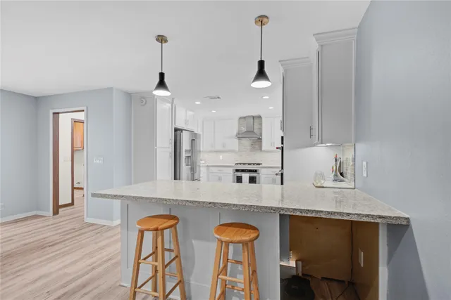 a kitchen with cabinets stainless steel appliances and a counter space