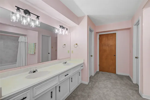 a spacious bathroom with a sink a large mirror and a shower