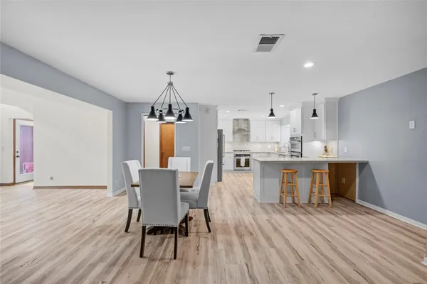 a kitchen with kitchen island granite countertop a sink a center island and cabinets