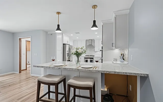 a kitchen with stainless steel appliances granite countertop a kitchen island hardwood floor sink stove and wooden floor